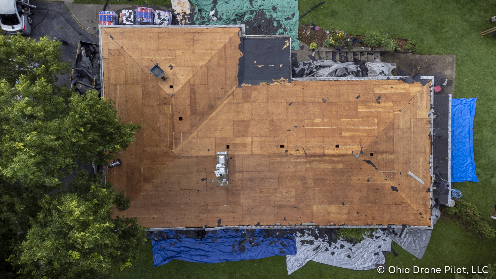 Top down view, © Ohio Drone Pilot, LLC of a l-shaped ranch house with all of it's roofing material removed