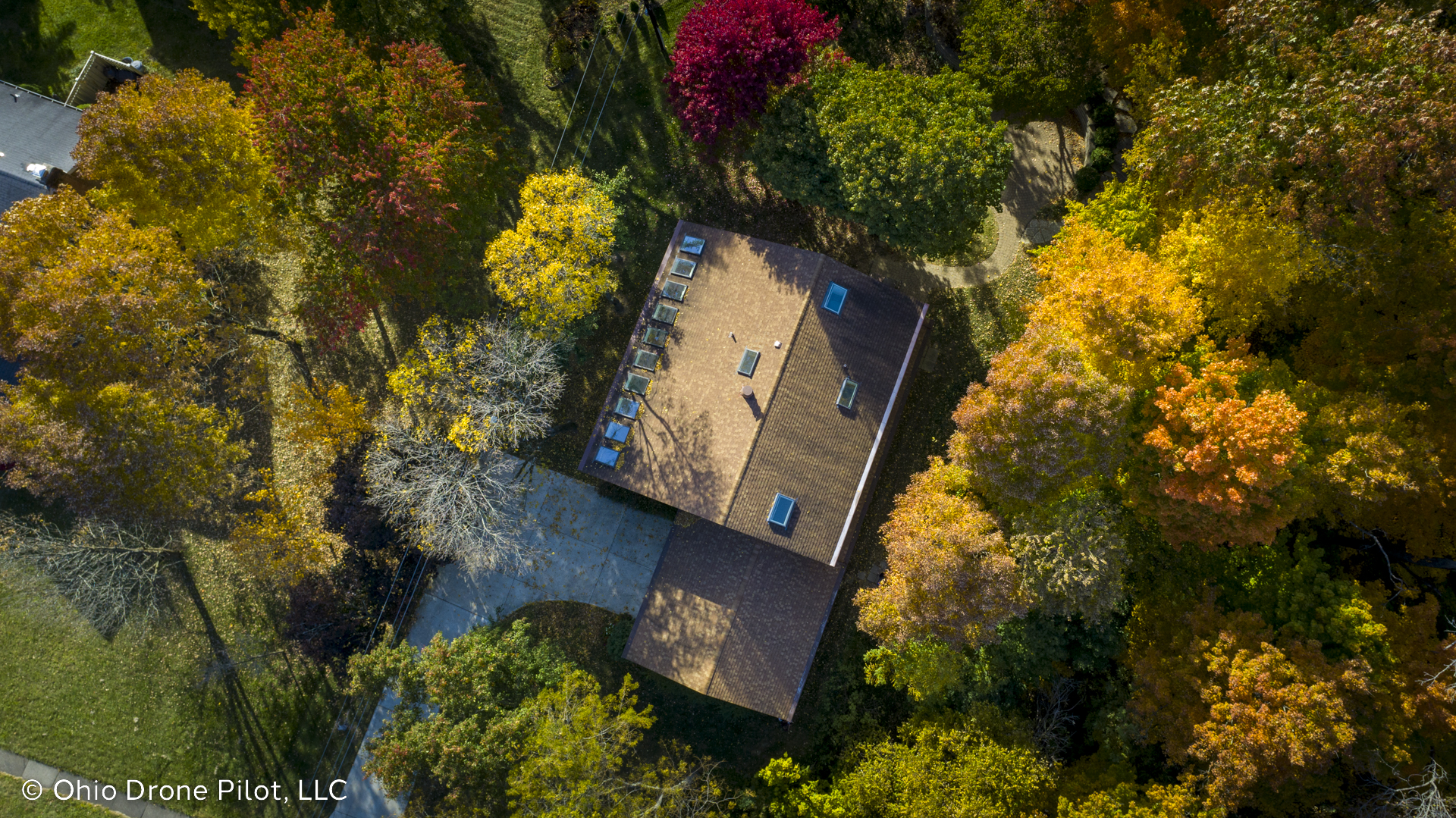 Looking down at a house surrounded by lovely autumn trees