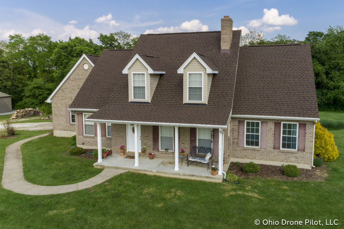 Angled front view of a Cape Cod style house with a newly installed roof