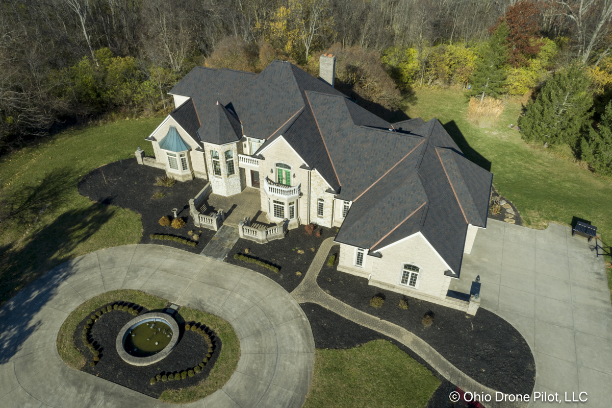 Wider aerial photo of a large, beautiful home and its newly installed roof