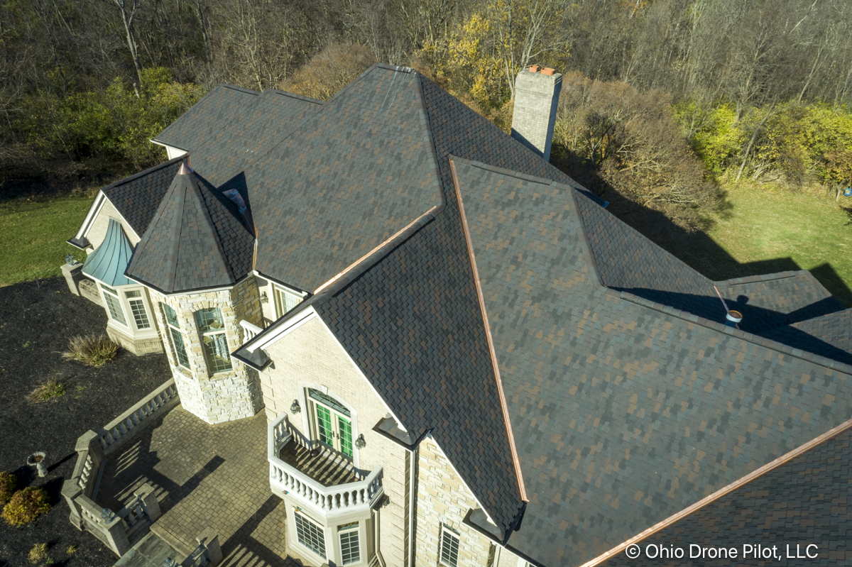 Closer aerial photo of a large, beautiful home and its newly installed roof