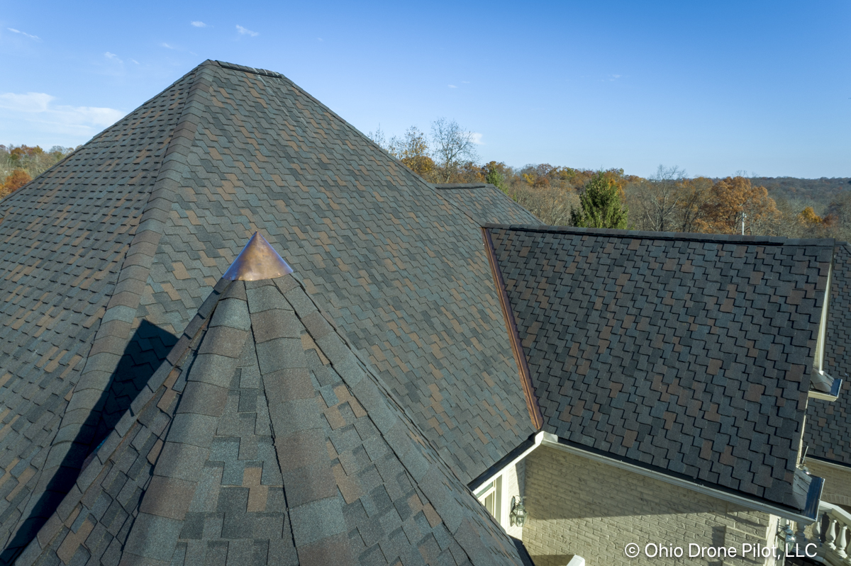 Detailed, close-up photo of a newly installed roof including a spire with a copper tip