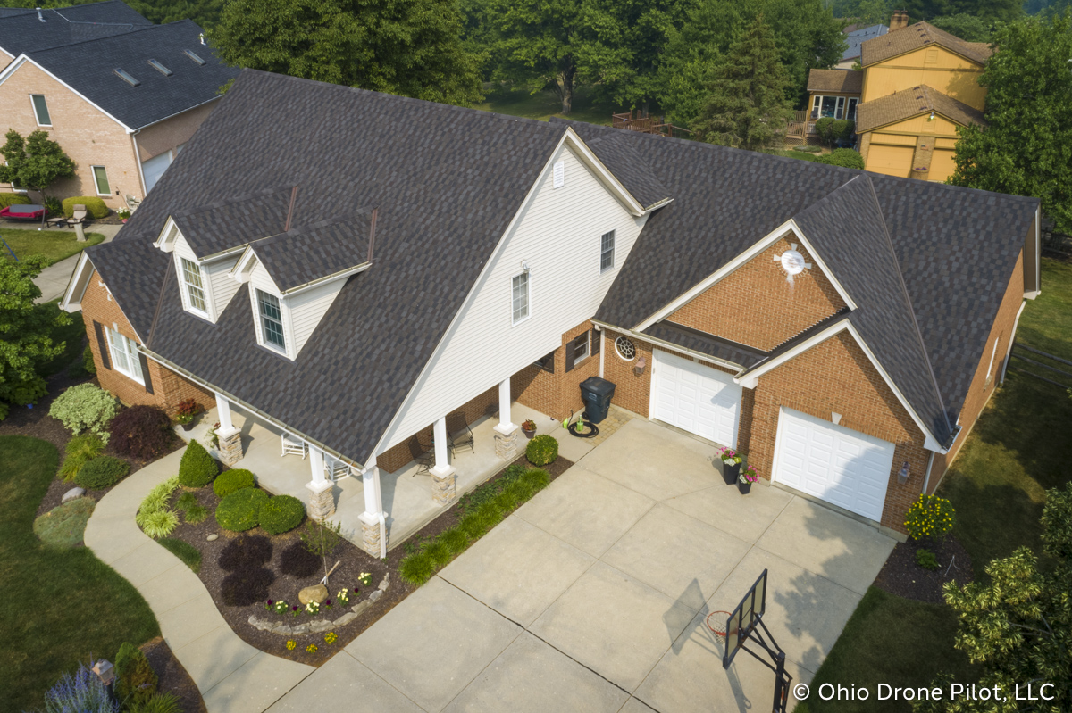 Aerial, off-center view of a newly installed roof on a beautiful 2 story home. Photography by Ohio Drone Pilot, LLC