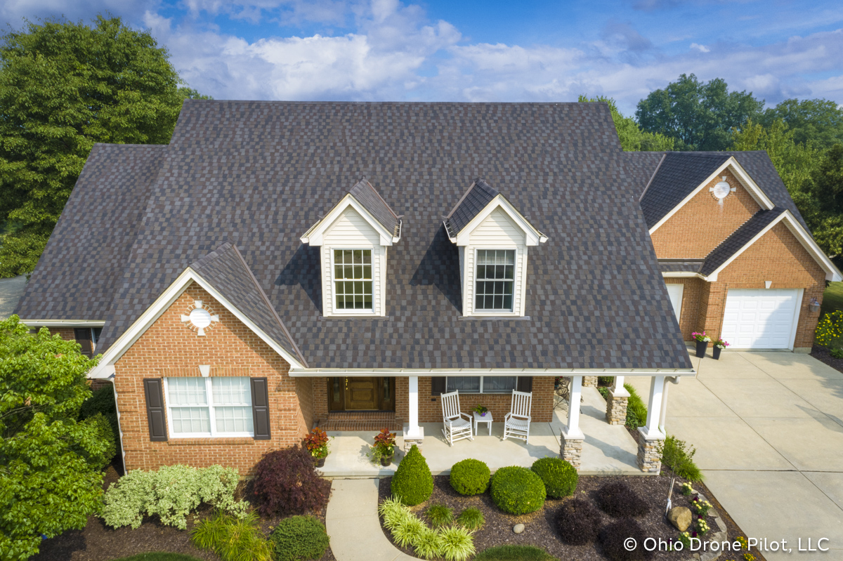 Aerial, frontal view of a newly installed roof on a beautiful 2 story home. Photography by Ohio Drone Pilot, LLC